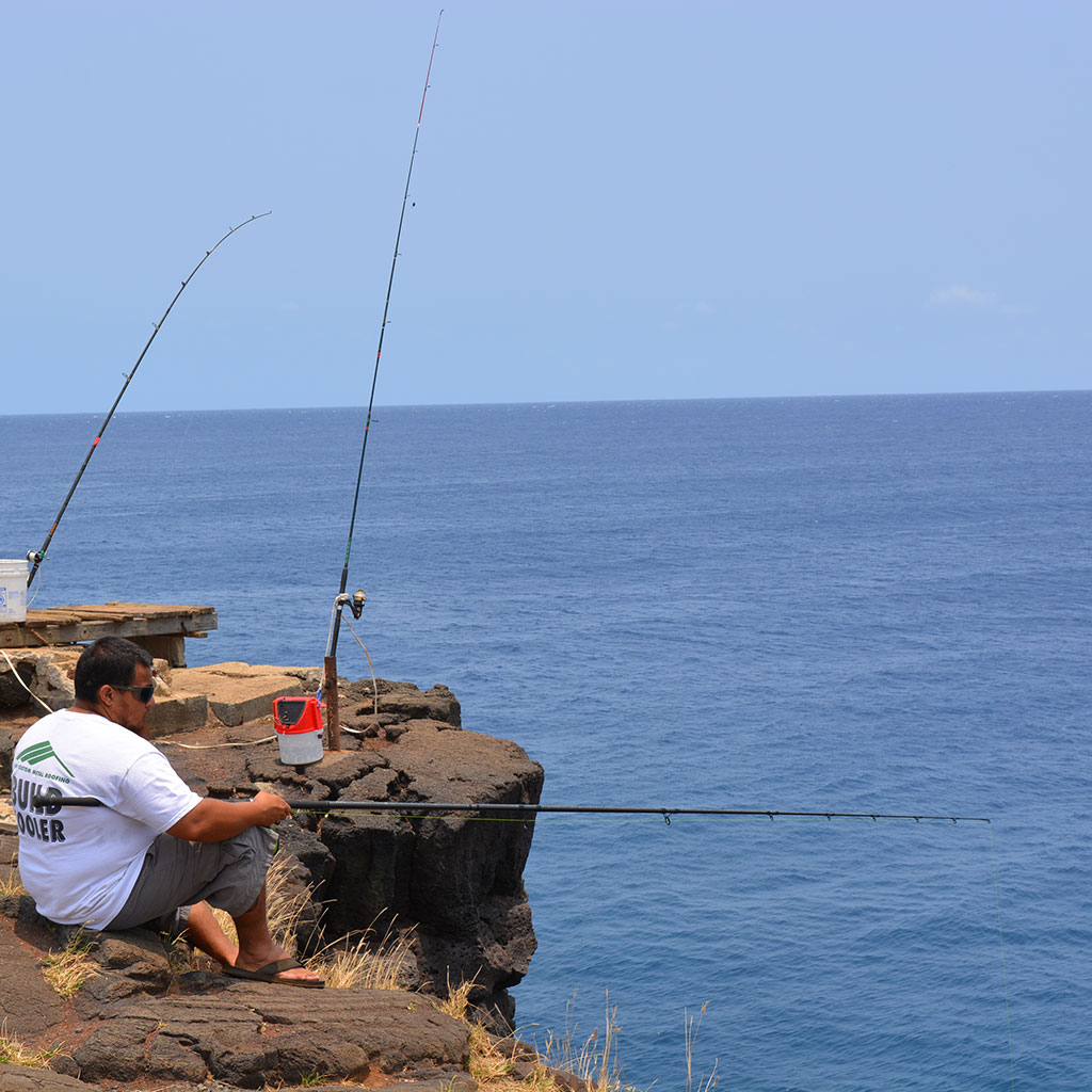A man fishing at South Point - a must visit place during your Big Island driving tours