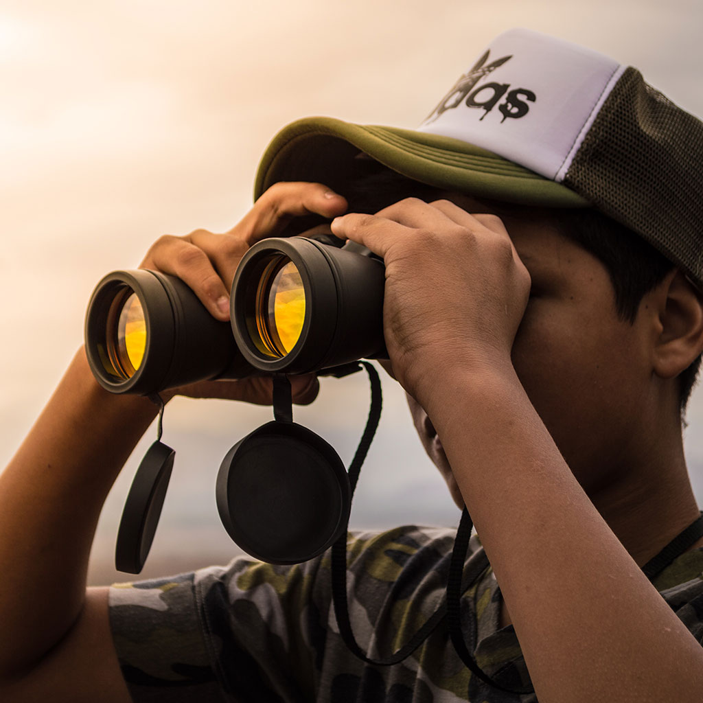 A guy observing wildlife with a binoculars - another Big Island vacation essential