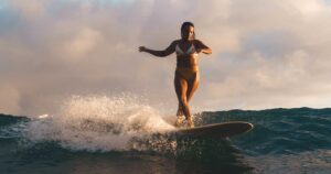 woman in bikini surfing on the beach