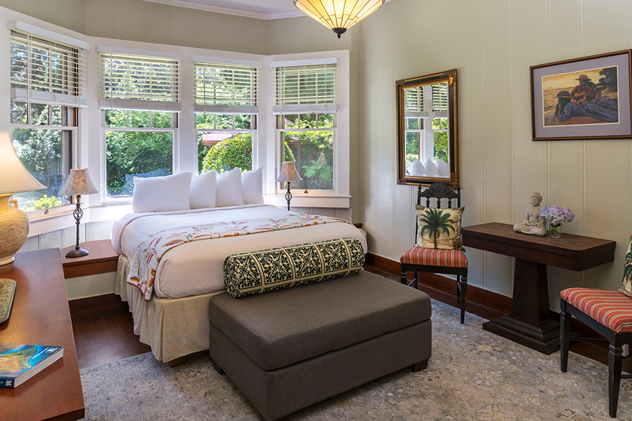 Owner's suite overview of bedroom with queen bed, small desk and book shelf