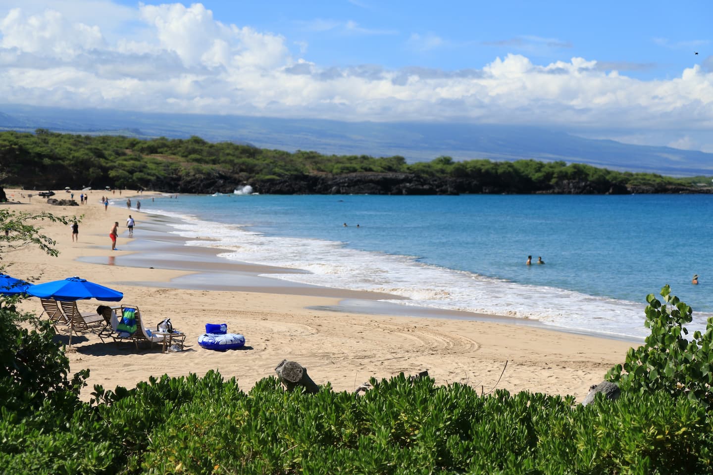 Chairs and umbrellas set up along the shoreline of Hapuna Beach