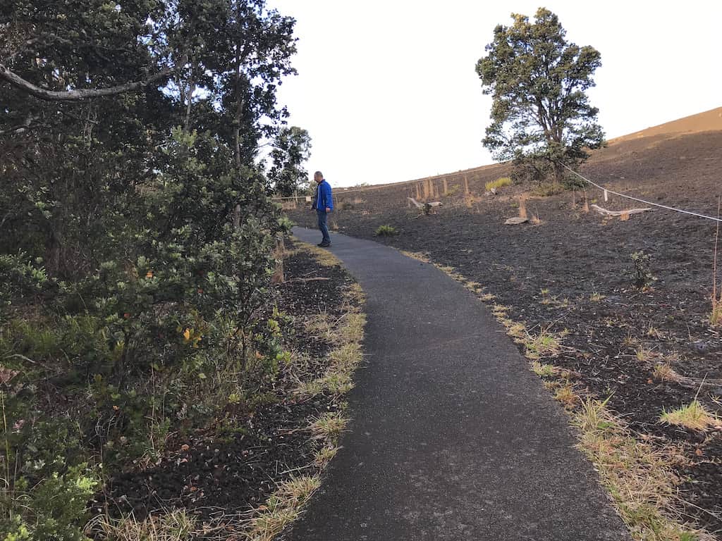 A man walking along a paved trail at Hawaii Volcanoes National Park