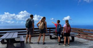Parents and their children looking out on an overlook along Chain of Craters Road during a family trip to Hawaii